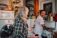 A touching moment in a cozy kitchen between a senior and a caregiver, showcasing warmth and care.